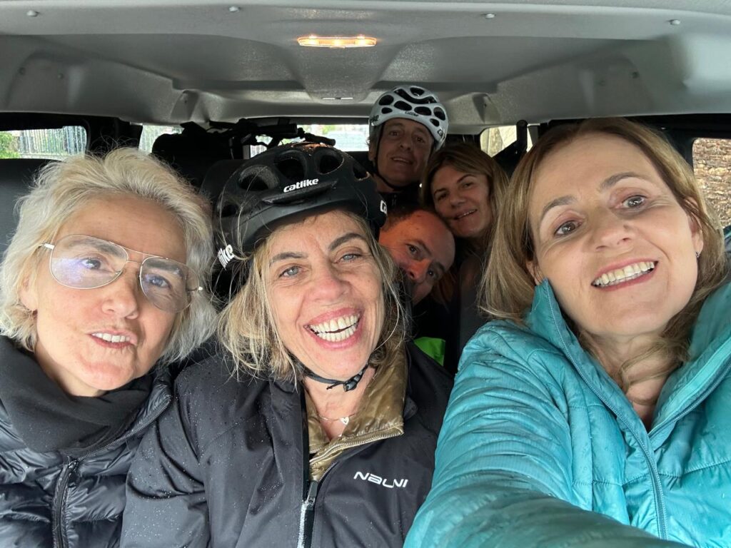 A foto mostra um grupo de brasileiros em um carro se deslocando para iniciar uma viagem de bicicleta pela Europa.