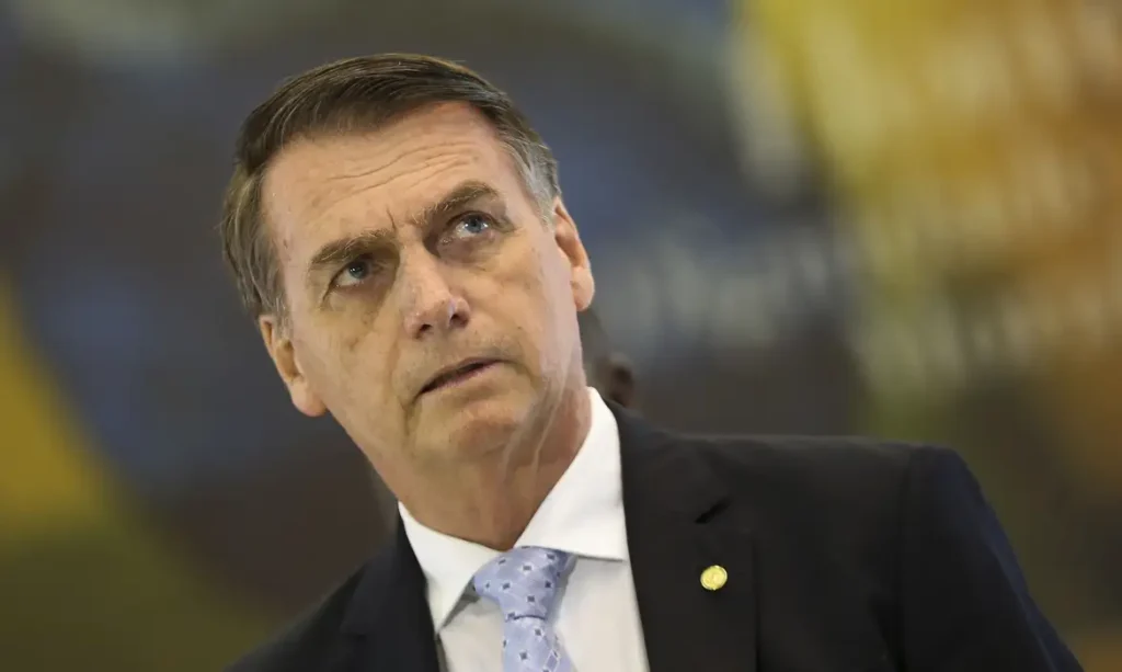 A foto mostra o ex-presidente Jair Bolsonaro. Ele é um homem branco com cabelos grisalhos e olhos claros.