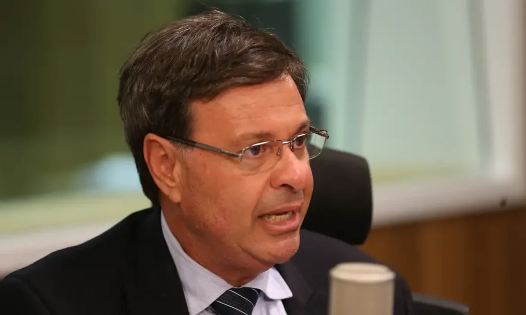 A foto mostra o ex-ministro do Turismo, Gilson Machado. Ele é um homem branco, com cabelos castanhos e usa óculos.