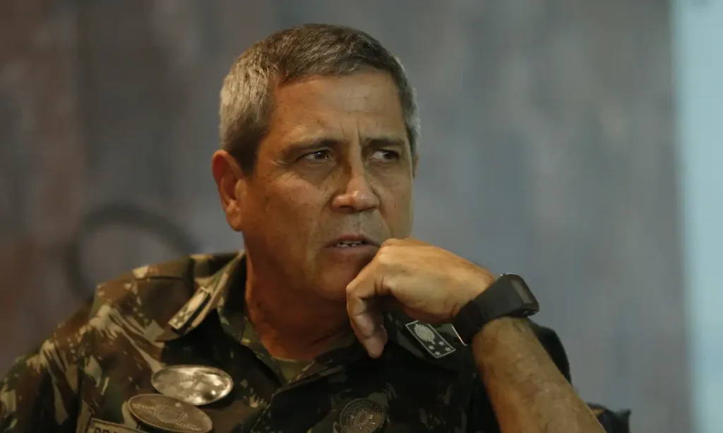 A foto mostra o general Braga Netto, ex-ministro da Defesa. Ele é um homem branco, com cabelos grisalhos e usa farda militar.