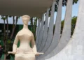 A foto mostra a estátua da Justiça em frente ao prédio do STF em Brasília.