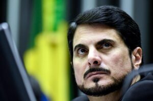 A foto mostra o senador Marcos do Val. Ele é um homem branco com barba e cabelo petos.