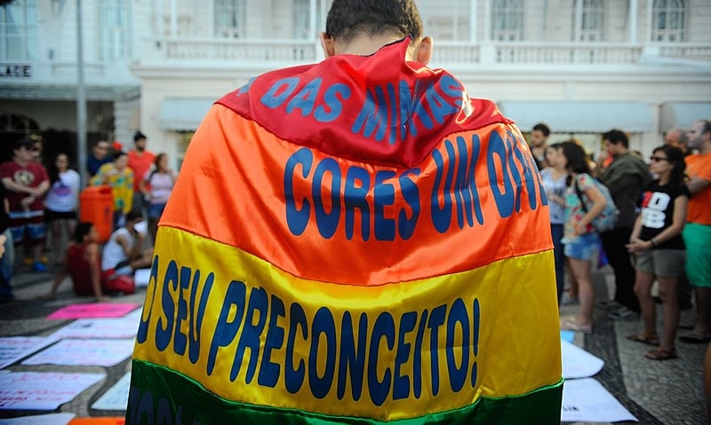 Militante enrolado na bandeira do movimento LGBTQIA+