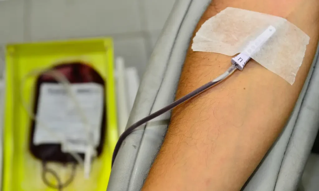 A foto mostra uma pessoa fazendo transfusão de sangue.