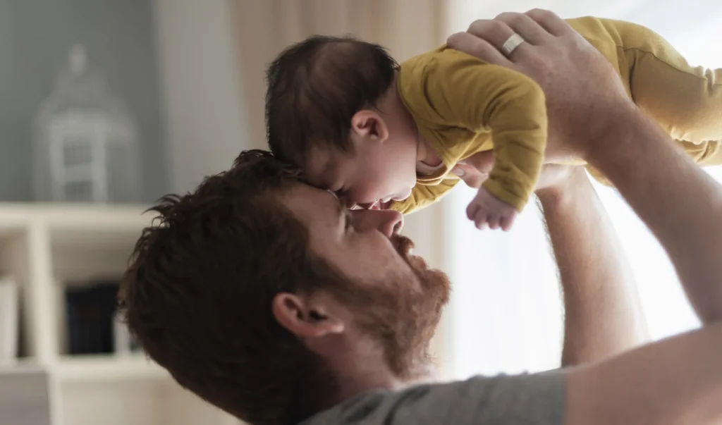 pai segurando bebe carinhosamente