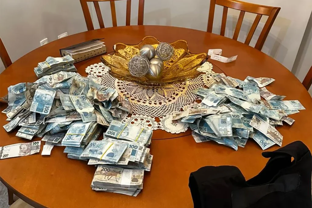 Cédulas de real sobre mesa redonda, apreendido pela PF, em SC