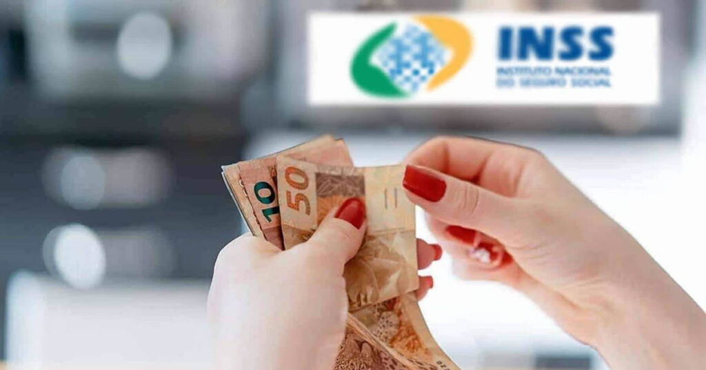 Mãos de mulher contam dinheiro à frente de uma placa do INSS