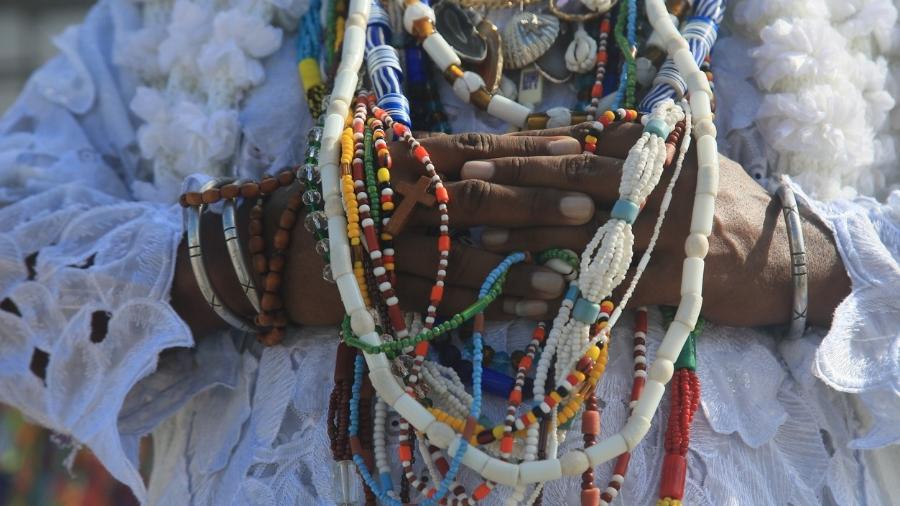 imagem de peito de religiosa do candomblé cheio de colares e missangas