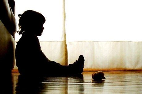 silhueta de criança sozinha sentada no chão