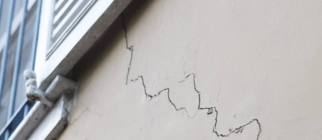 Parede com edificação cheia de fissuras