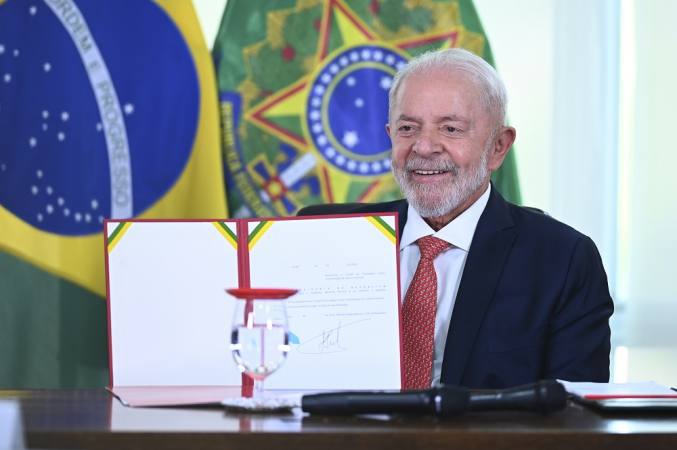 Presidente Lula mostrando lei sancionada