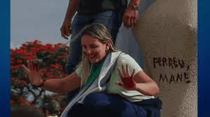 Debora do batom em cima da estátua da justiça em Brasília com as ãos sujas de batom