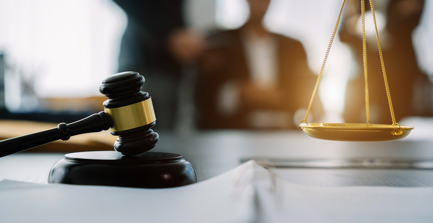 Símbolos da justiça: martelo, documentos e balança dourada sobre uma mesa