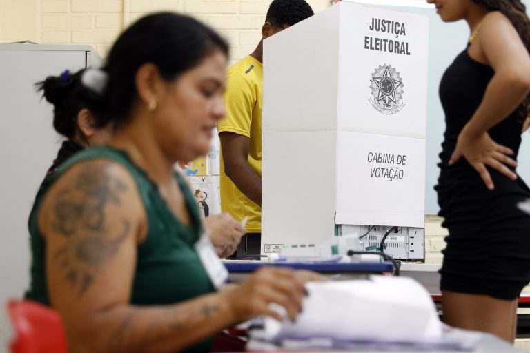 Mulher mesária durante seção de votação em dia de eleições gerais