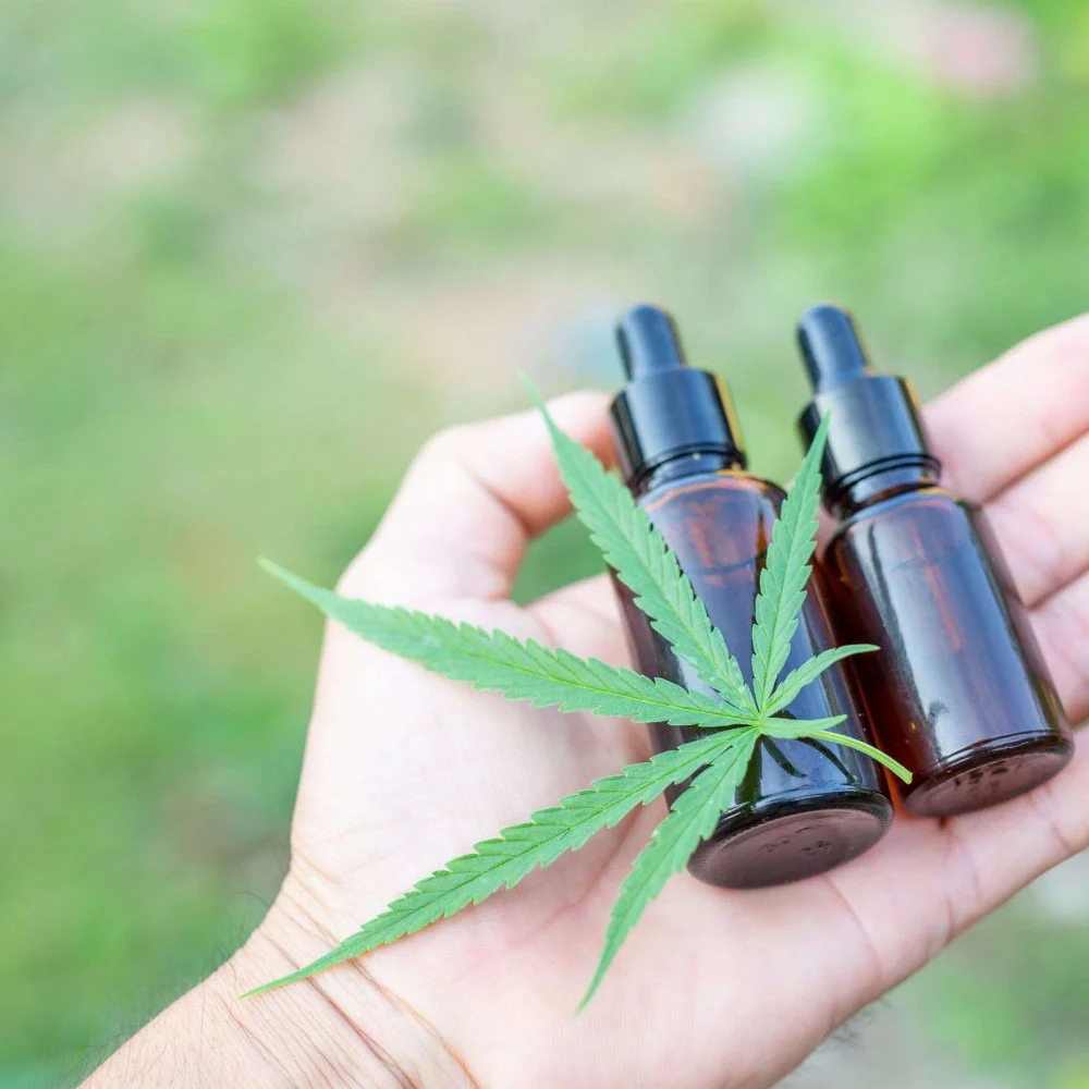 folha de cannabis sobre dois potes pequenos de remédio