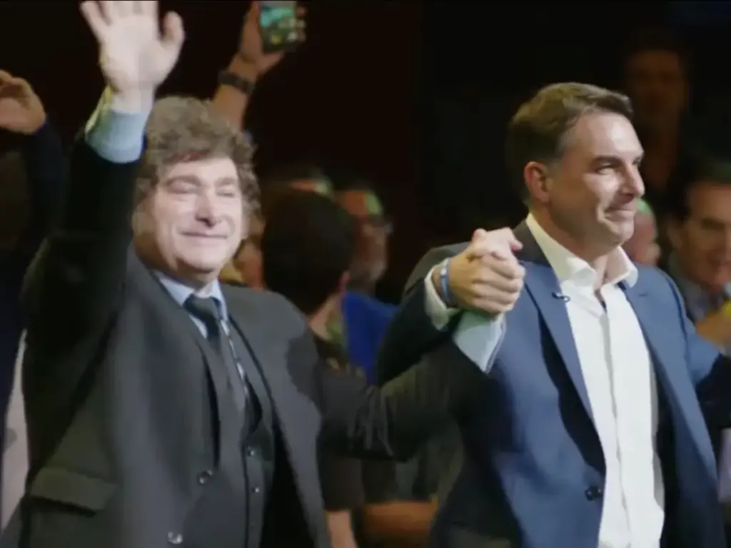 Milei de mãos dadas com Flávio Bolsonaro na convenção do PL