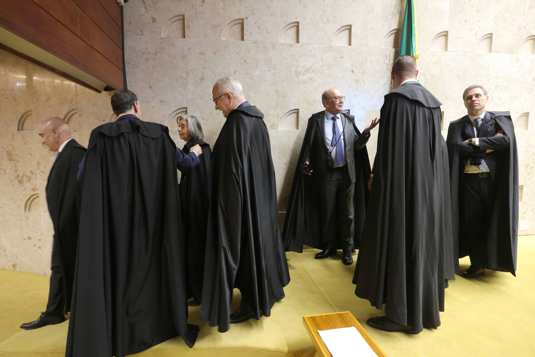 Ministros do STF com capas saindo do plenário