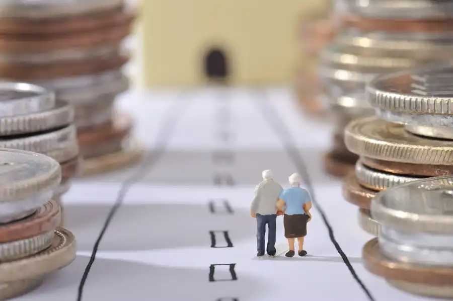 casal de velhnhos caminham em lugar com moedas fazendo montanhas ao redor