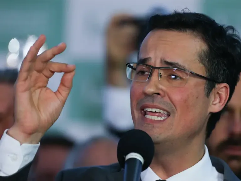 Deltan falando para publico com semblante de indignacão