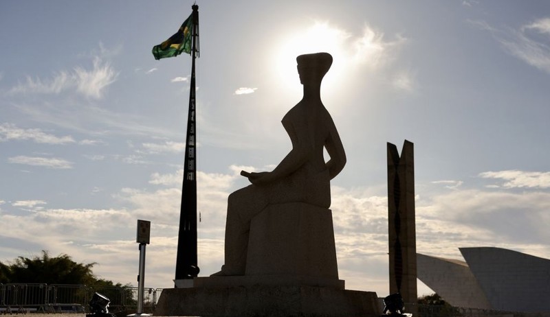 imagem da estátua da justiça em sobra no contra luz