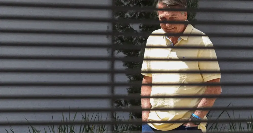 Ex-presidente Jair Bolsonaro atrás de muro com grades